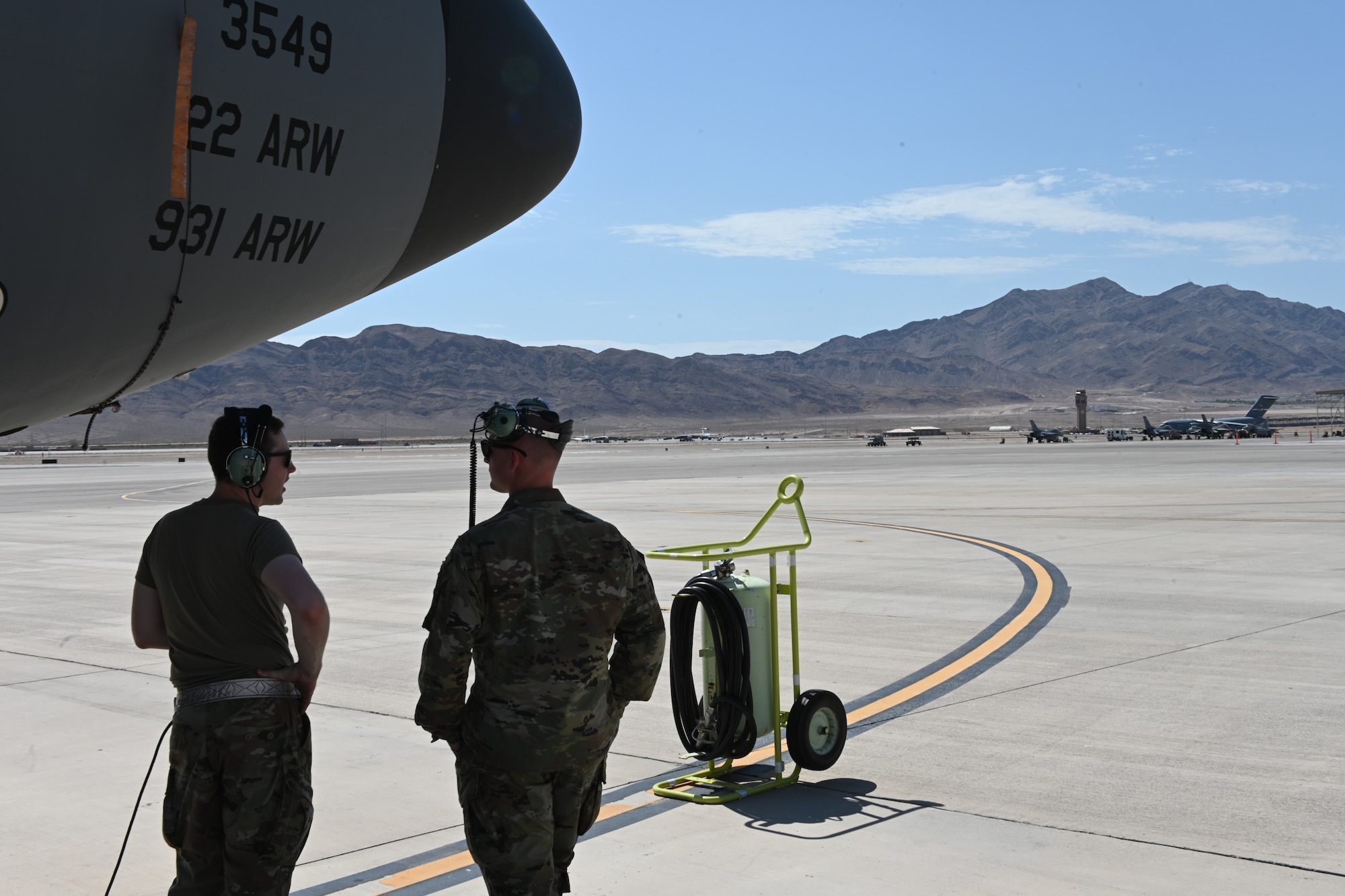 Tech. Sgt. Corey Agres and Senior Airman Jeffrey Richardson, 22nd Aircraft Maintenance Squadron crew chiefs, await the arrival of a KC-135 flight crew July 20, 2021, at Nellis Air Force Base, Nevada.