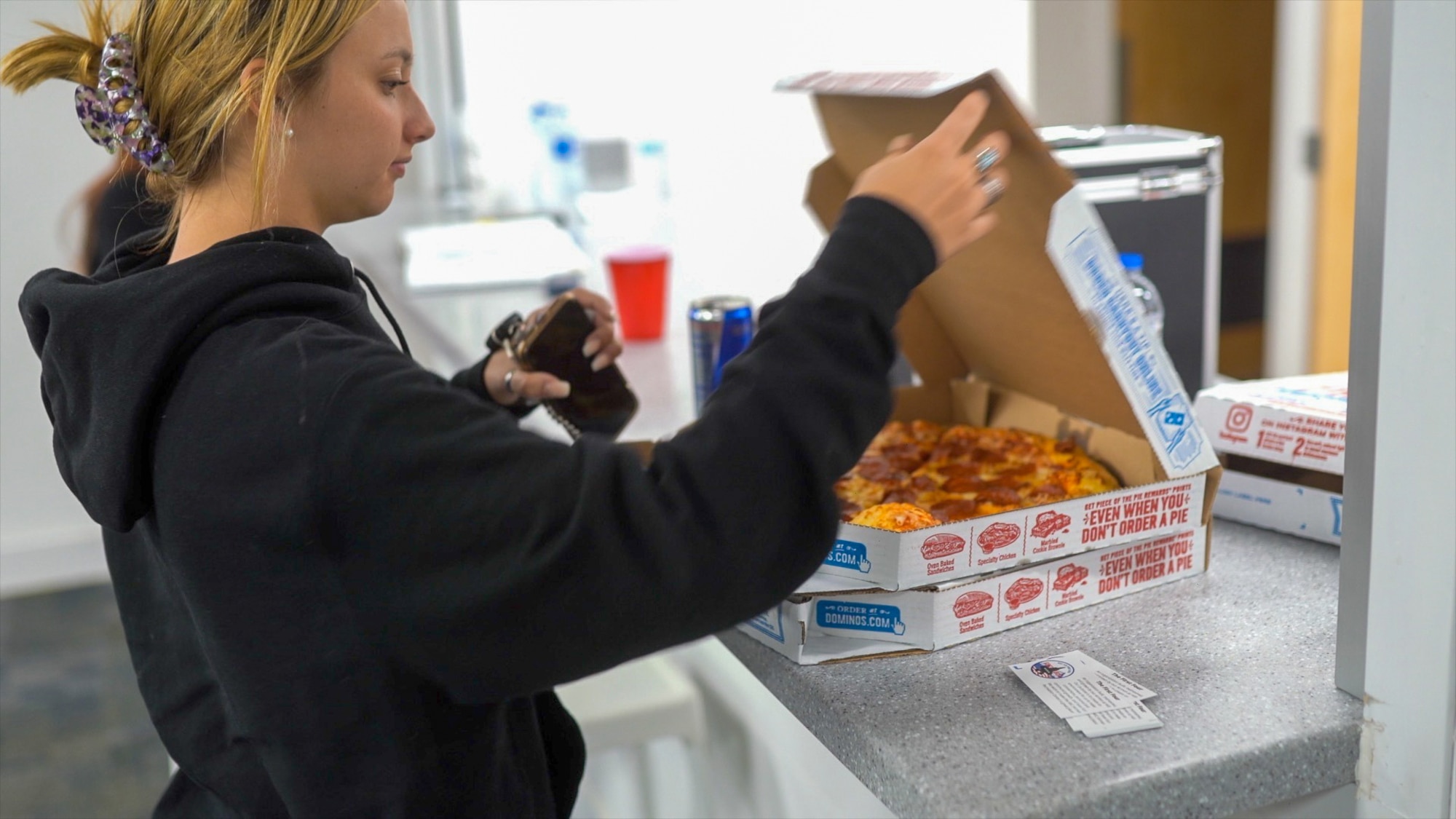 Airman 1st Class Ella Valley, an Airmen Against Drunk Driving volunteer, opens a pizza box during an on-call shift at the Airmen Recreation Center July 18, 2021, at Hill Air Force Base, Utah. AADD is a free program available to Hill military members, civilian and contractor employees on Fridays and Saturdays from 11 p.m. to 3 a.m. (U.S. Air Force photo by 2nd Lt. Taylor Ferry)