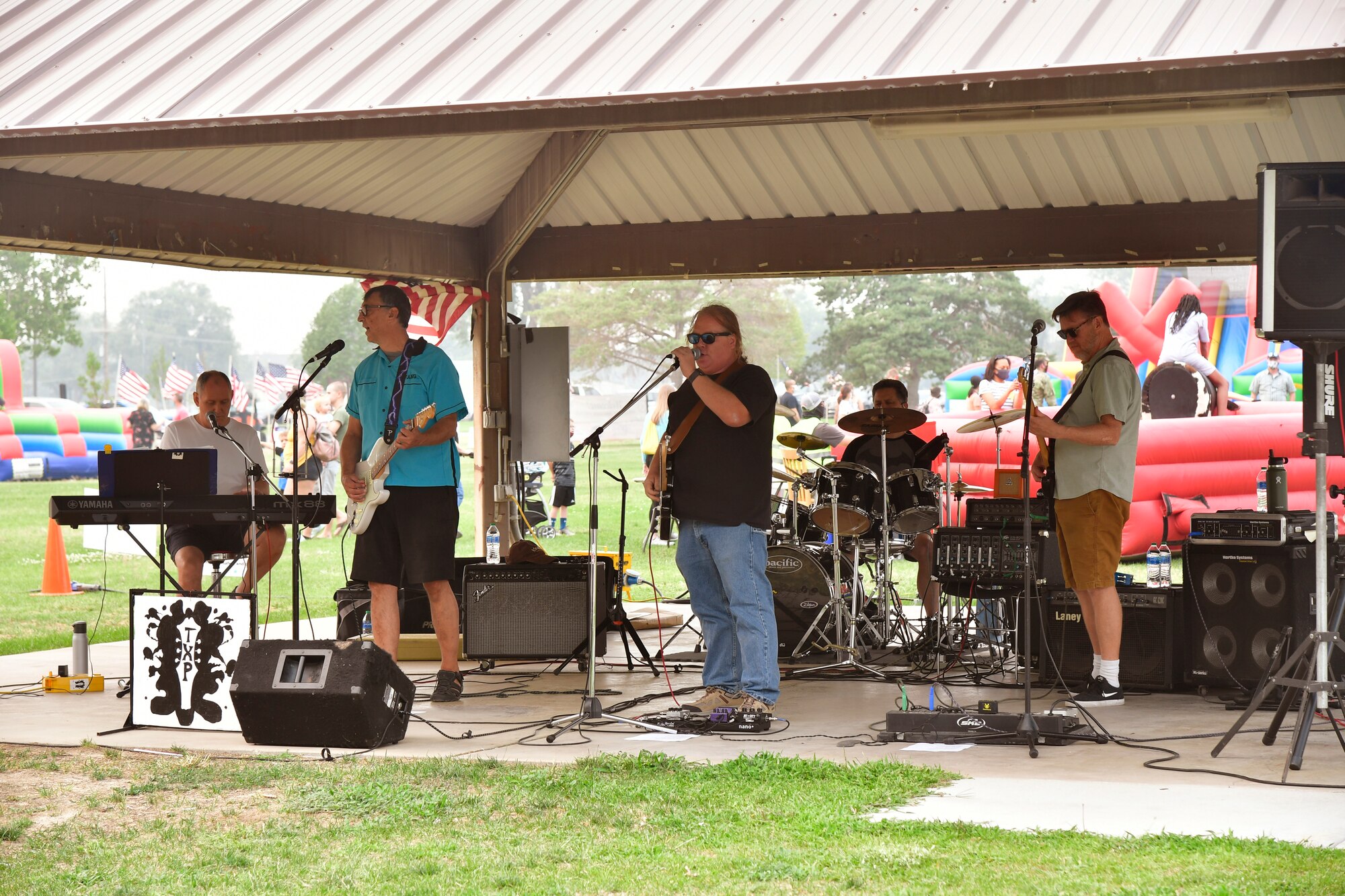 A music band performing underneath a pavilion.