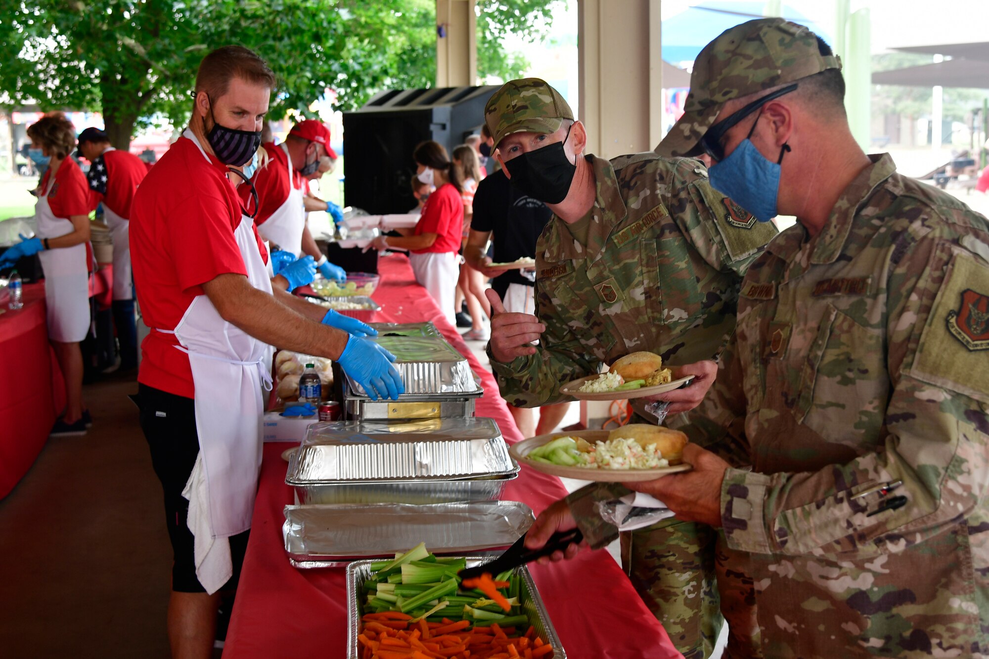 Volunteers serving food to Airmen in a food line.