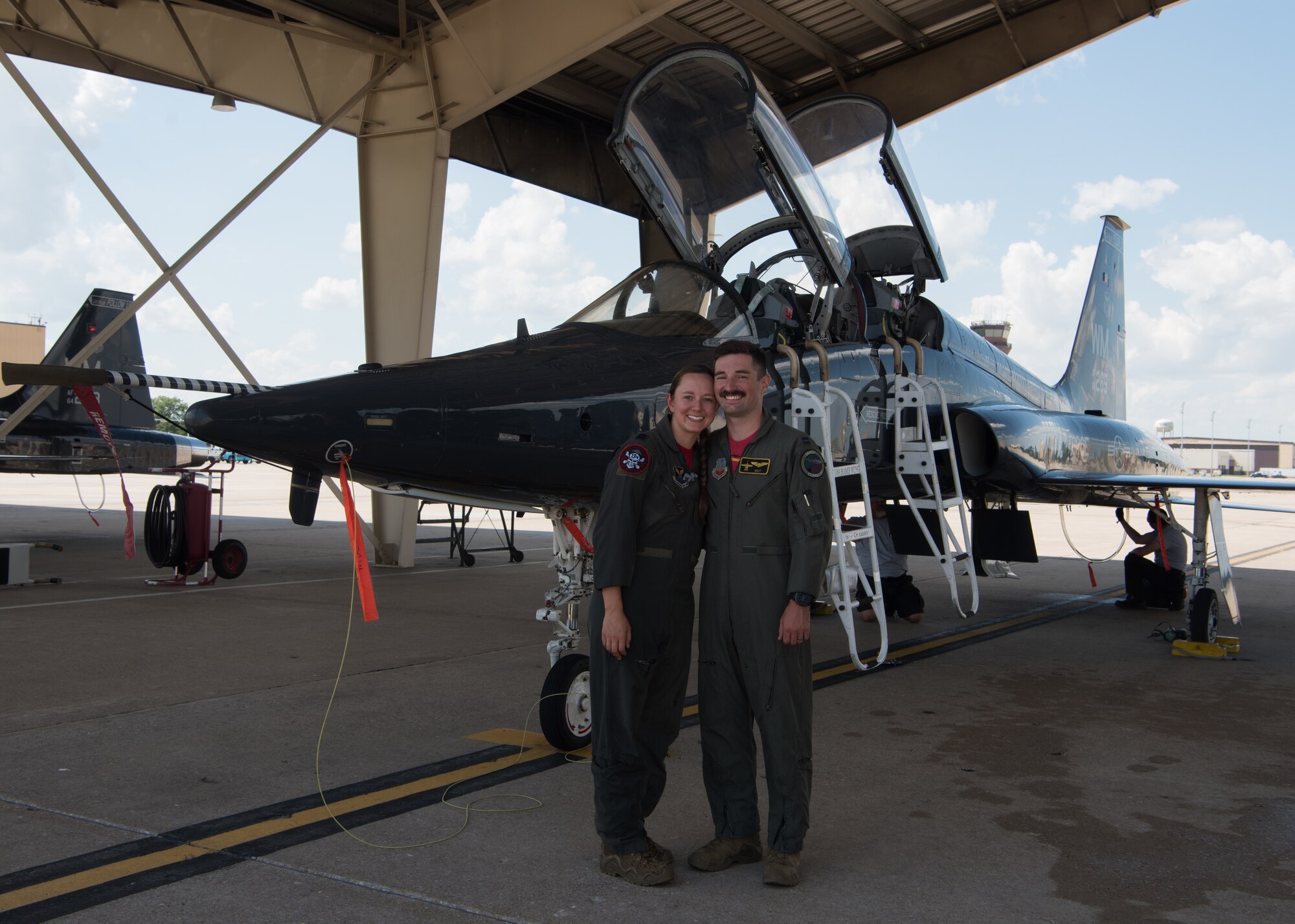 Captains Stephen and Lacey Orians stand in front of a T-38 Talon.