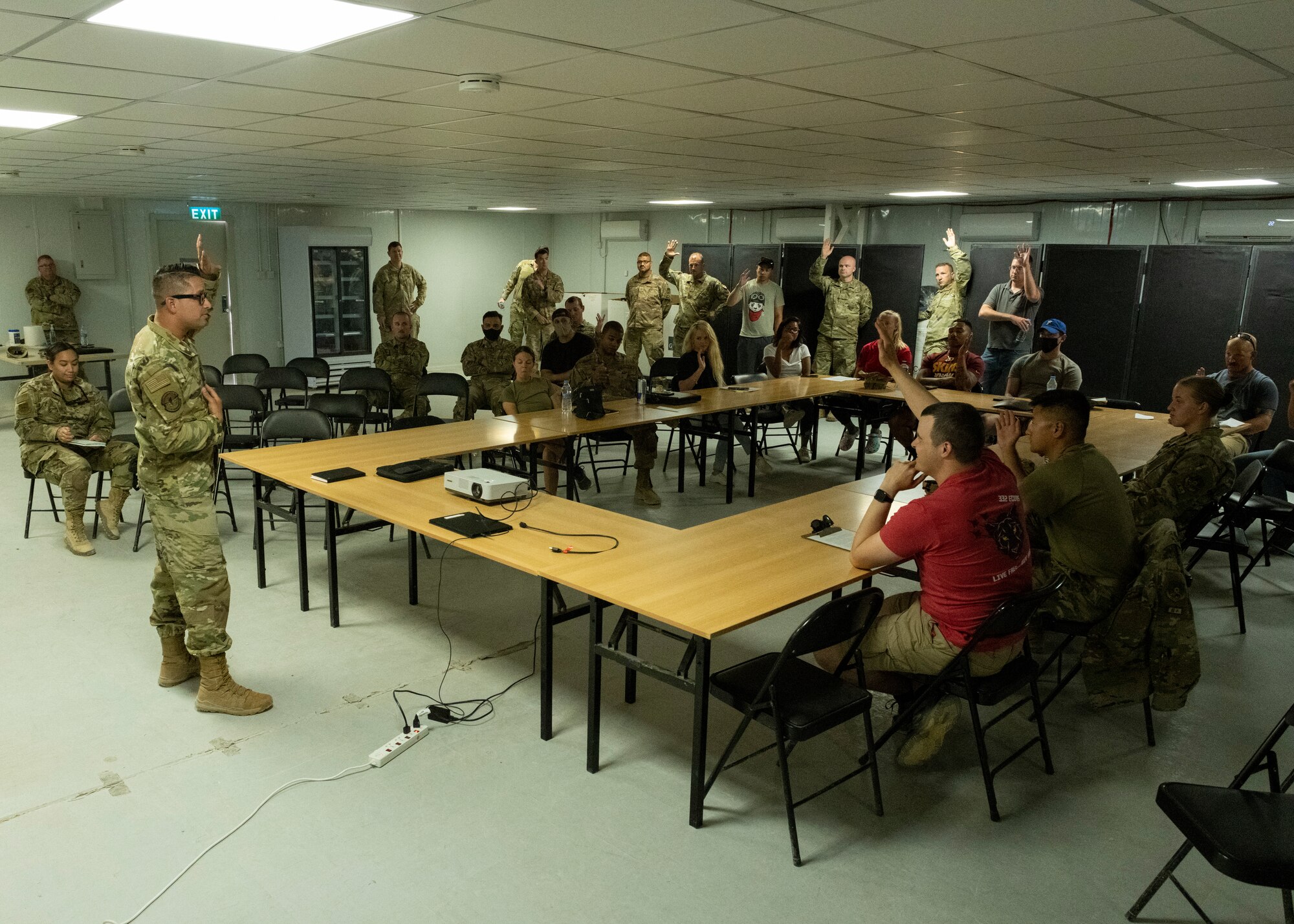 U.S. Service members raise their hands in a classroom