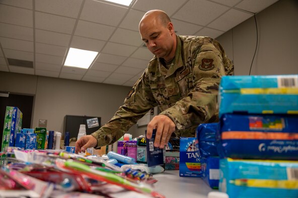 An Airman arrange donated items on a desk
