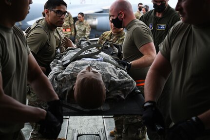 Airmen load mannequin patients onto a KC-46 Pegasus during mobile medic training at the Northern Strike 21 exercise Aug. 2-8, 2021. The Air Dominance Center at the 165th Airlift Wing in Savannah, Georgia, hosted over 85 Air National Guard Airmen from multiple medical units across the United States and its territories for the training.