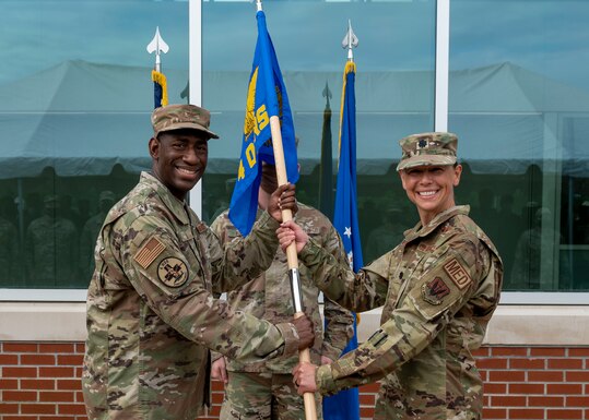 Lt. Col. Hatie McAviney, right, 4th Operational Medical Readiness Squadron incoming commander, receives the guidon from Col. Dolphis Hall, 4th Medical Group commander during the 4th OMRS assumption of command ceremony at Seymour Johnson Air Force Base, North Carolina, August 6, 2021.