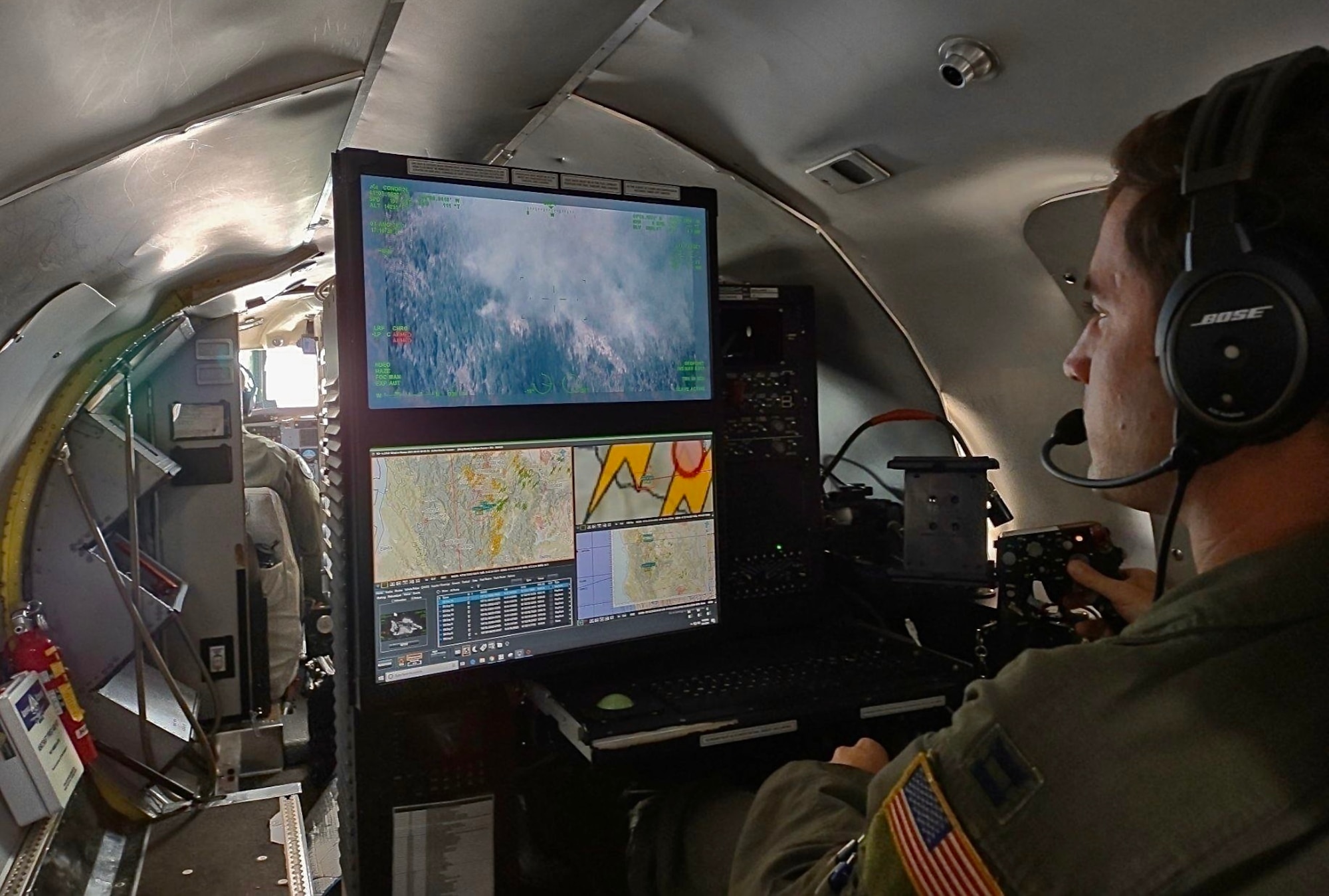 Capt. Alex McArdel, 141st Air Refueling Wing RC-26B aircraft mission systems officer, uses the aircraft's camera to map and detect wildland fires in the north-western region of the United States, August 1, 2021.
