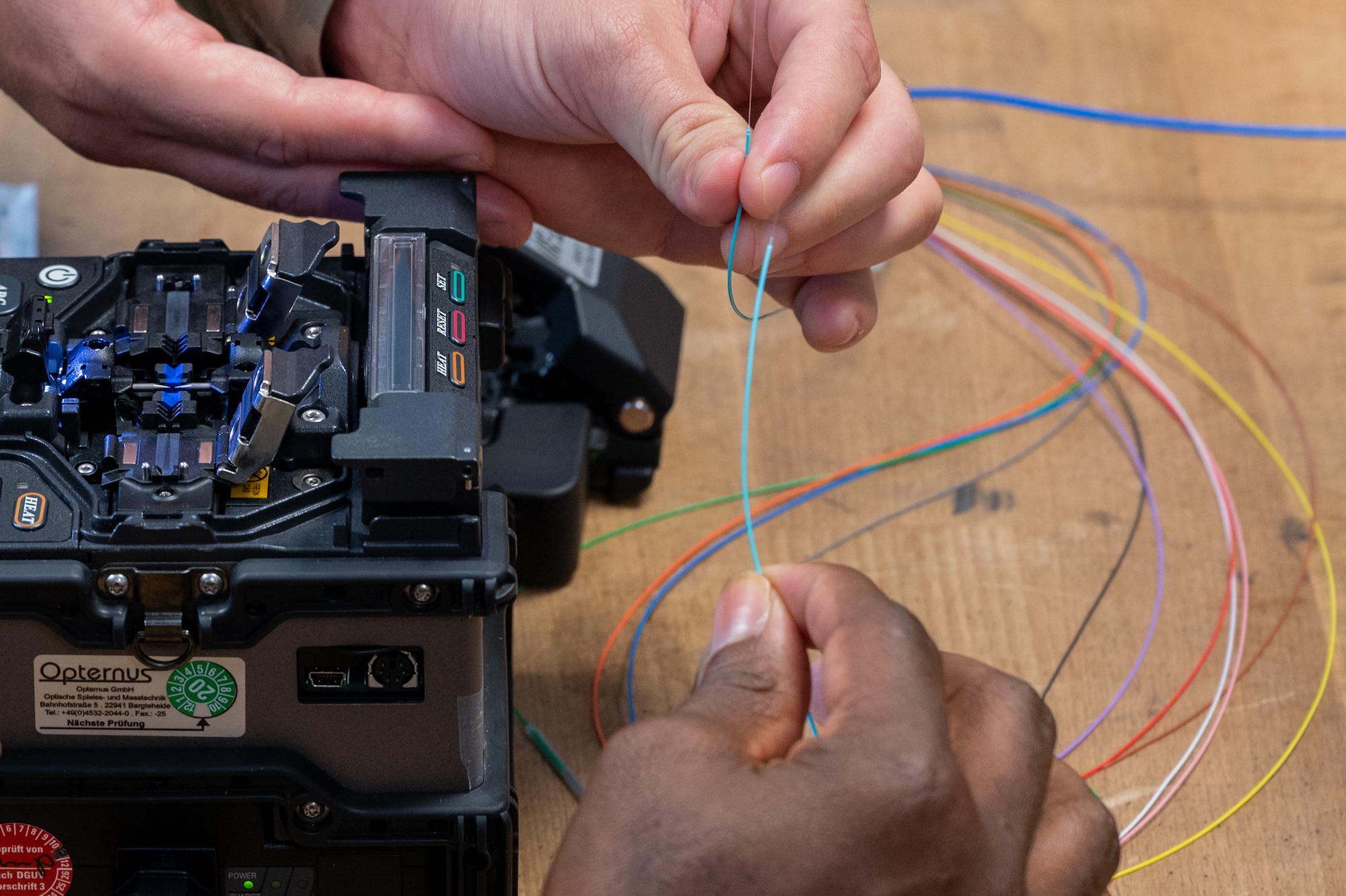 Close-up of hands working with fiber cables.