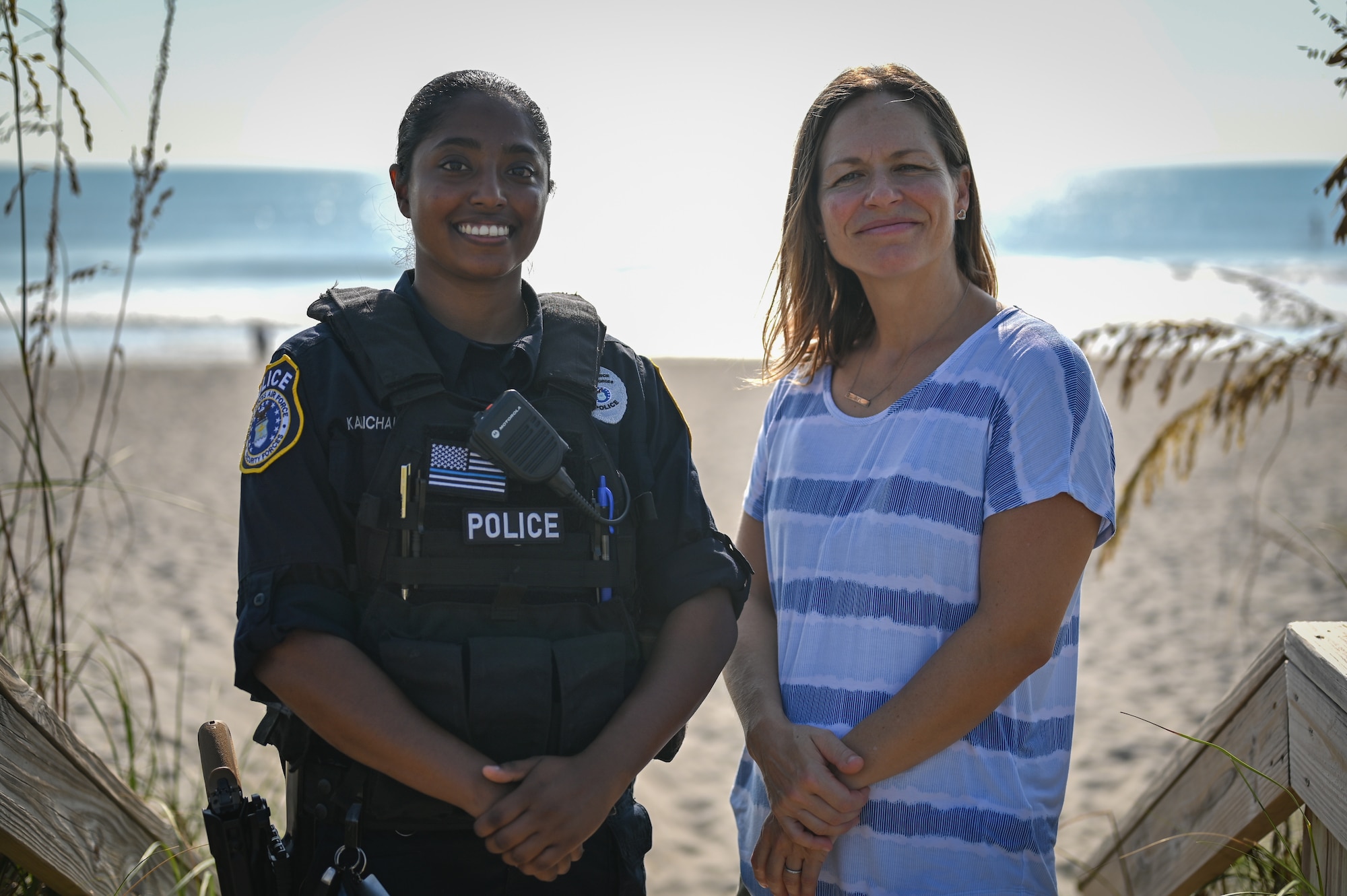 Christy Kalicharan (left), 45th Security Forces Squadron police officer and Gretta Lowry (right), Cocoa Beach, Florida, resident pose for a group photo at Patrick Space Force Base, Florida, July 28, 2021. Kalicharan provided life saving aid to Lowry after she was bitten by a shark while surfing.