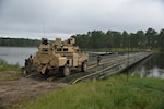 A heavy vehicle from 926th Engineer Brigade crosses a bridge July 20, 2021, at Fort Stewart, Georgia. The 361st and 310th Multi-Role Bridge Companies under the 926th Engineer Brigade joined the South Carolina National Guard’s 125th MRBC to build the wet gap crossing.