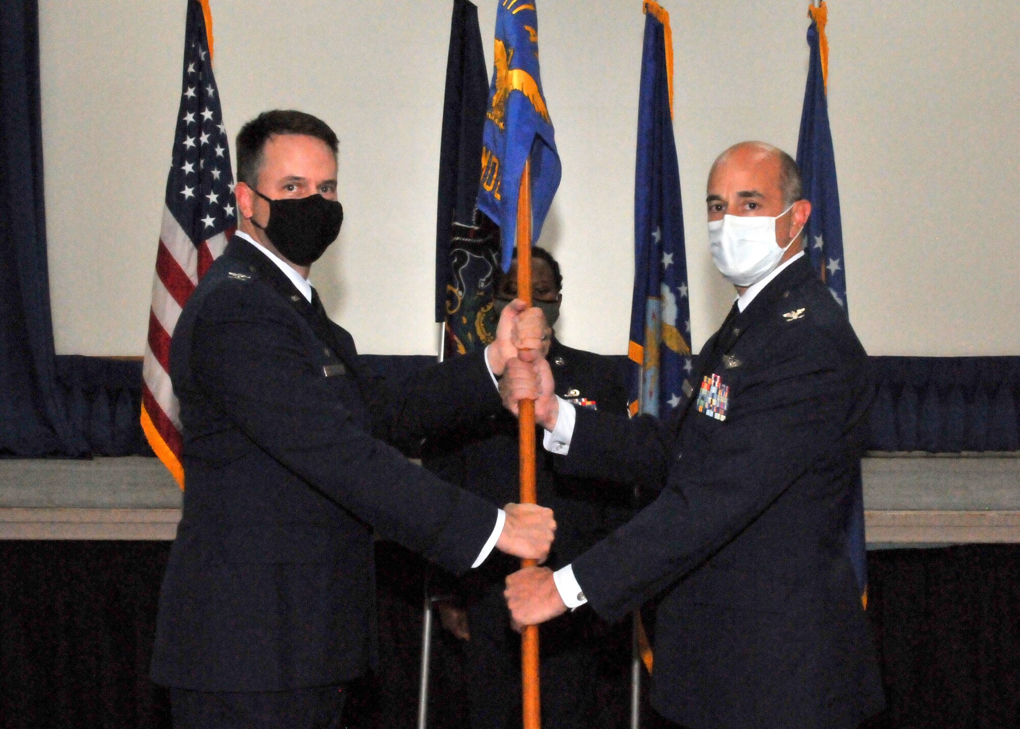 An Air Force colonel hands a guidon to a new commanding officer.