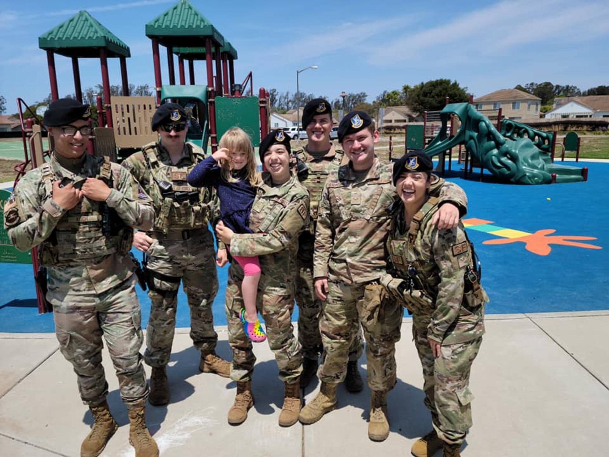 Six police officers pose for photo with little girl