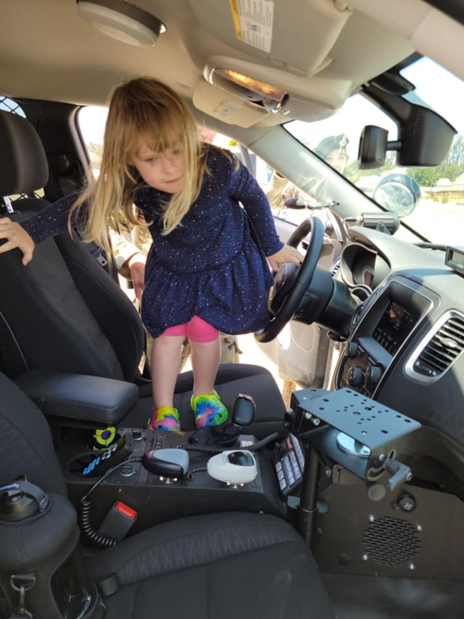 Little girl in exploring inside police car