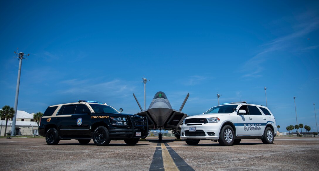 Two cars and an airplane are posed for a photo op