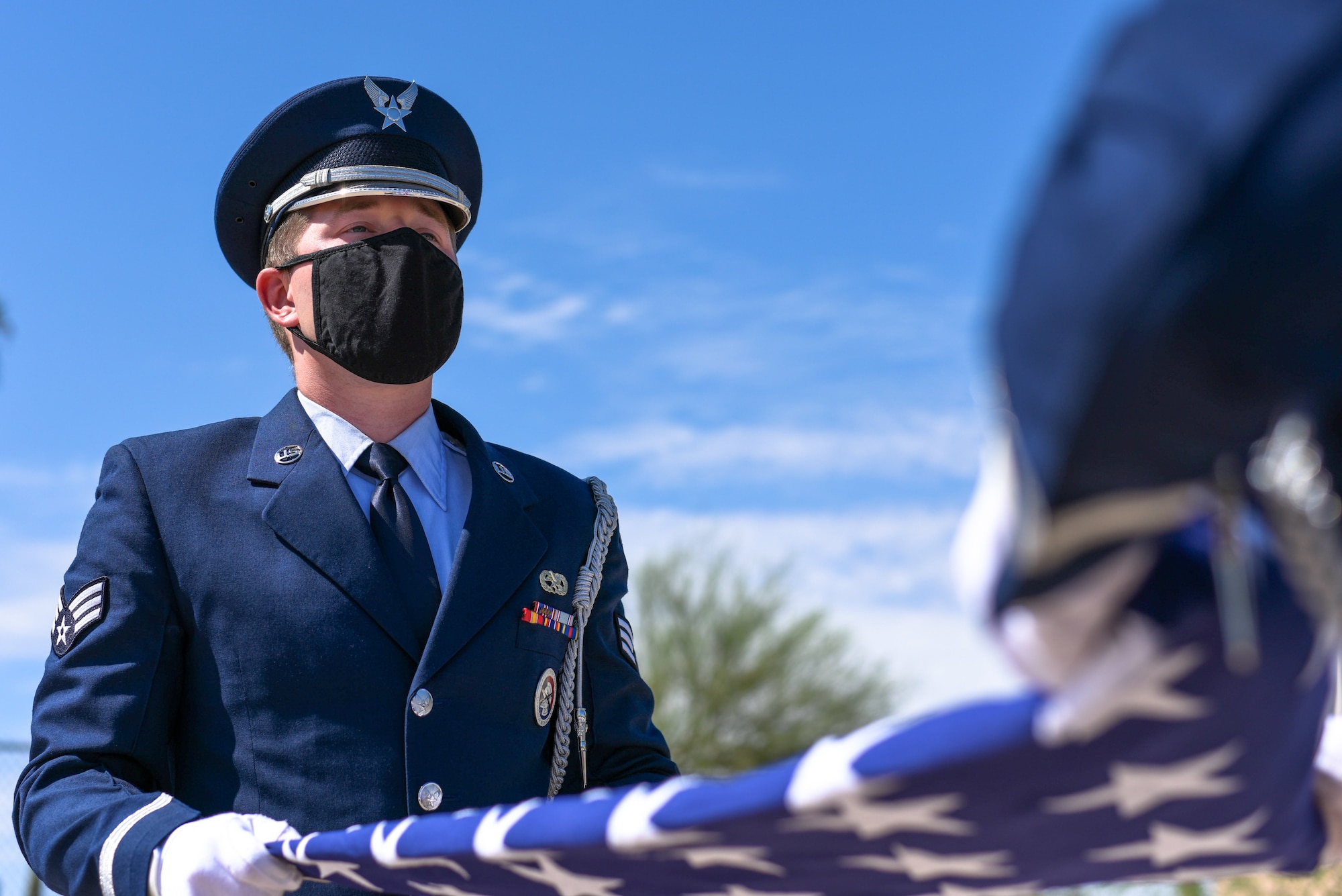 U.S. Air Force Senior Airman Blake Davidson, 56th Fighter Wing ceremonial guardsman, holds the American flag during a flag folding ceremony July 28, 2021, at Luke Air Force Base, Arizona. The Luke AFB Honor Guard is responsible for a large amount of Arizona’s ceremonies, providing coverage to six different counties. The base honor guard’s primary mission is to provide military funeral honors for active-duty members as well as retirees and veterans who served honorably in the U.S. Air Force and Army Air Corps. (U.S. Air Force photo by Senior Airman Caleb F. Butler)