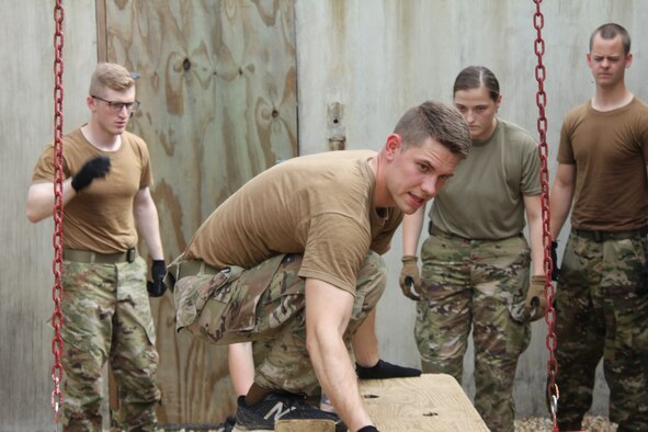 An Air Force ROTC cadet works his way through one of the obstacles on the Leadership Reaction Course