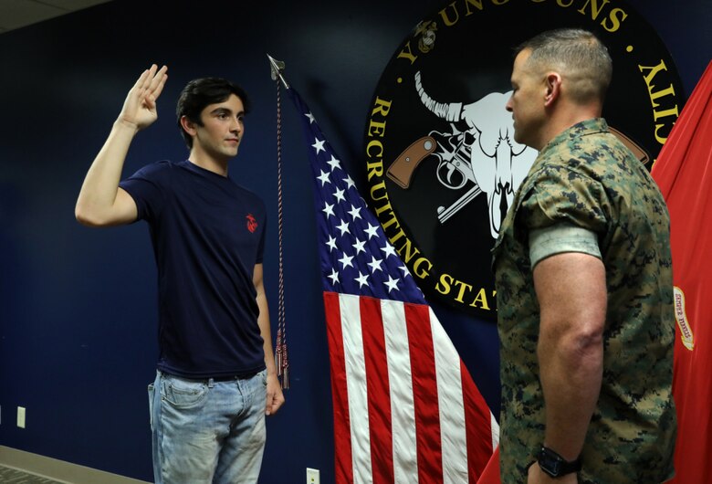 Daniel Hayek (left) takes his Oath of Enlistment from his father, Maj. Richard Hayek, the Commanding officer of Marine Corps Recruiting Station Kansas City, before signing an active duty contract with the U.S. Marine Corps at Kansas City Military Entrance Processing Station in Kansas City, Mo., July 26, 2021. By committing to the Marines, Daniel is poised to become a fourth-generation service member in his family-- following the footsteps of his mother, father, grandfather and great-grandfather. Daniel graduated from Navarre High School in Navarre, Fla., in 2020.