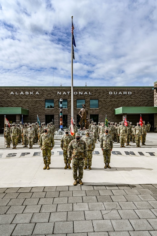 Members of the Alaska Army National Guard’s 297th Regional Support Group stand in formation at the Lestenkof Plaza on Joint Base Elmendorf-Richardson, Alaska, during a change of command ceremony Aug 7, 2021. During the ceremony Col. Matthew Schell relinquished command of the unit to Col. Thomas “Alex” Elmore. This event marked the first time the unit has gathered together since returning from their nine-month rotation to Poland, supporting the European Deterrence Initiative and Atlantic Resolve missions, in March. (U.S. Army photo by Sgt. Heidi Kroll)