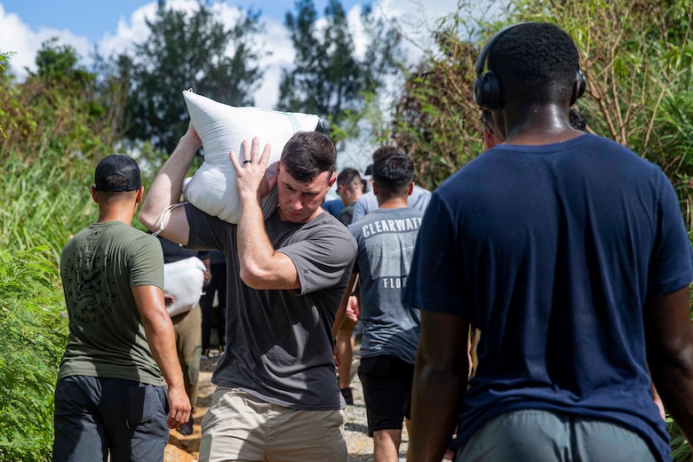 海兵隊員らが豊原地区のシーグラスビーチで、損傷した道路を補修するためにサンドバッグを搬送。