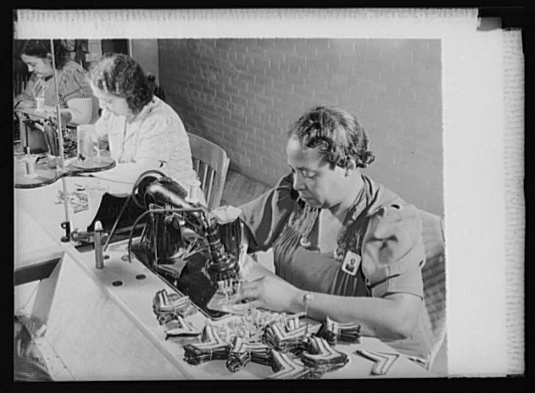 Women workers at the Philadelphia Quartermaster Depot stitch  chevrons for promoted enlisted men.