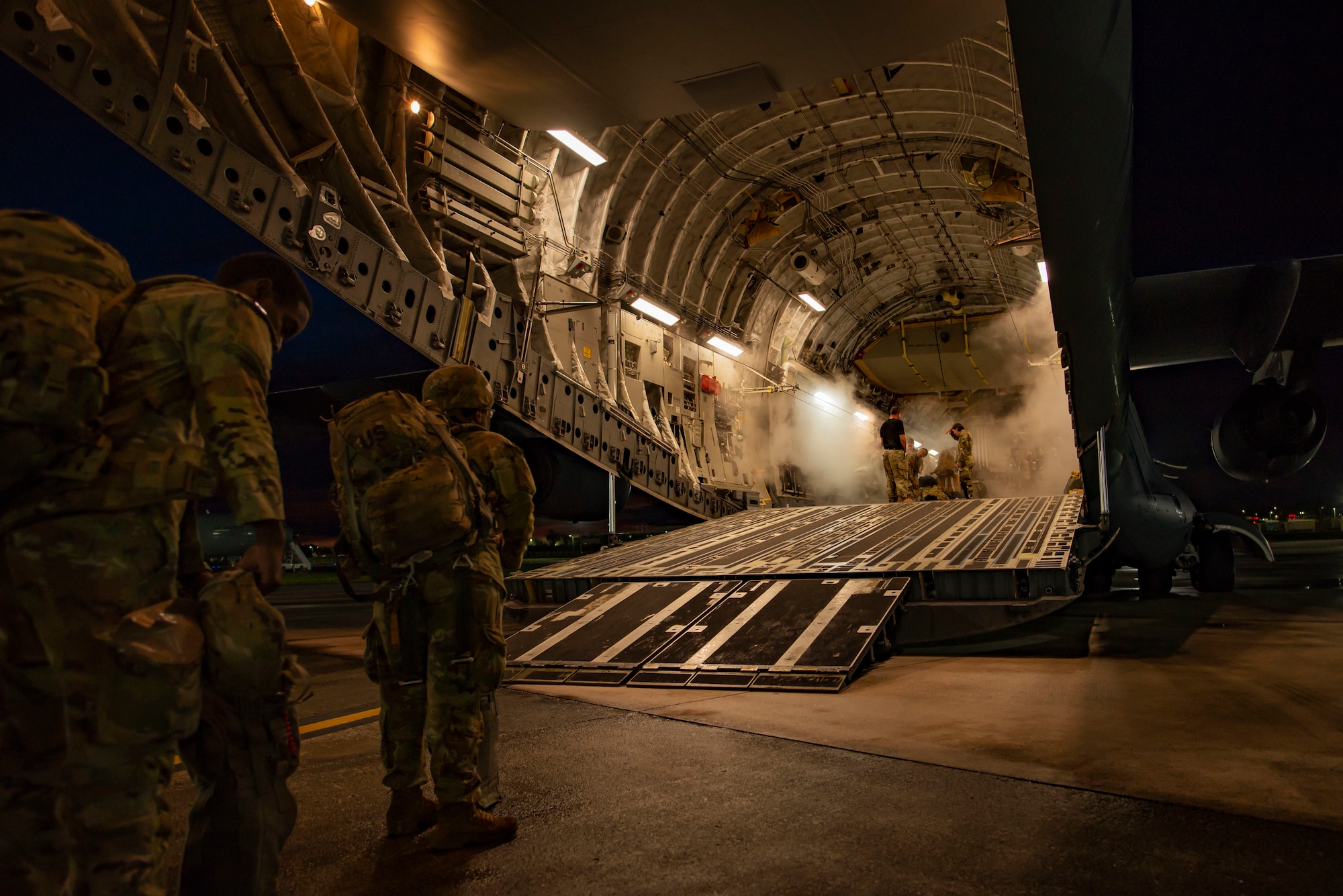 Two paratroopers wait to board a plane.
