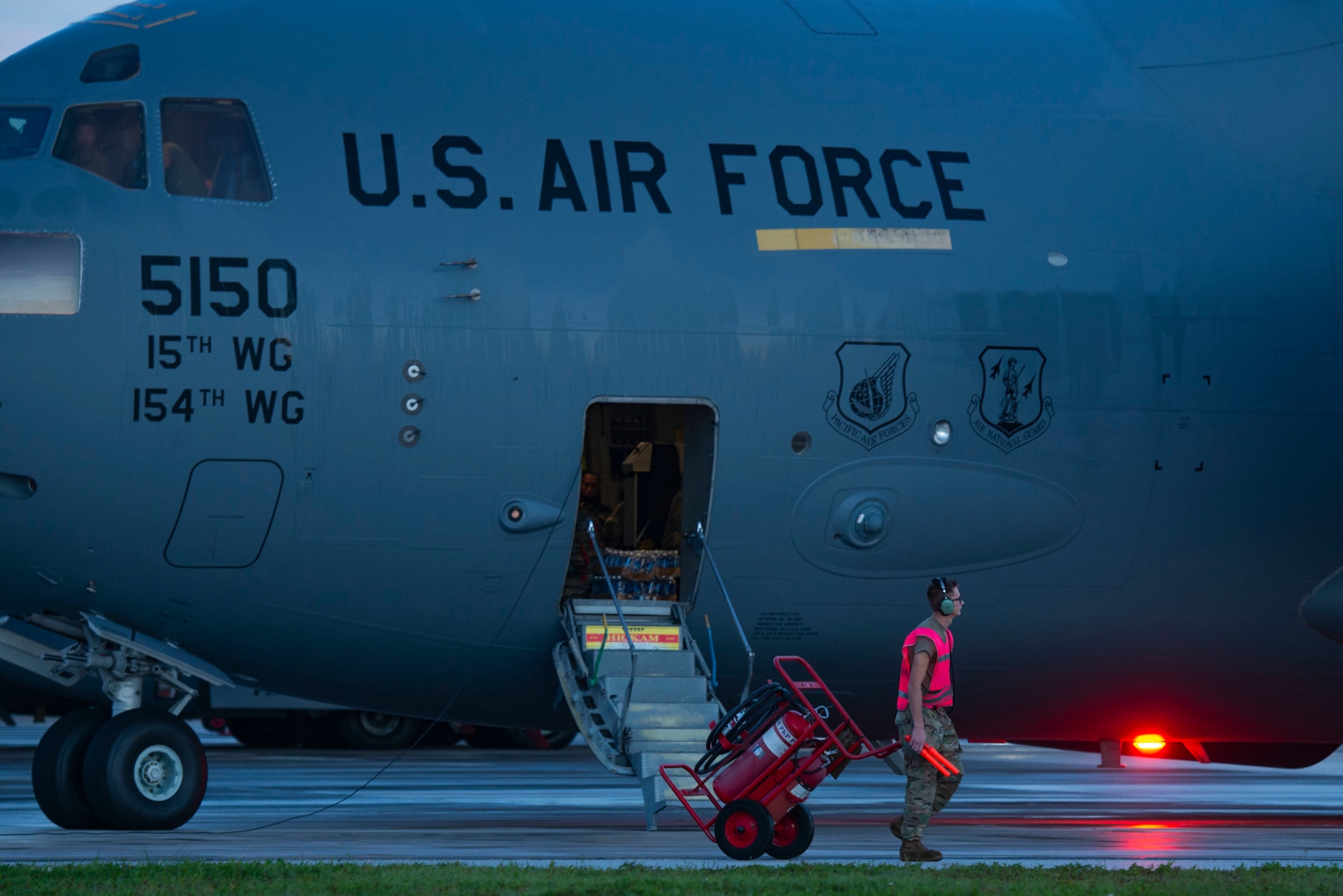 An airman walking alongside a plane for pre-flight inspection.