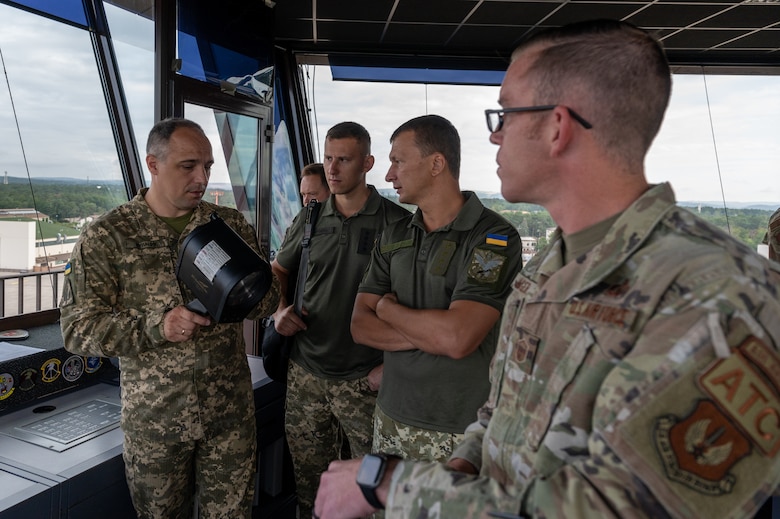 Service members standing in an air traffic control tower.