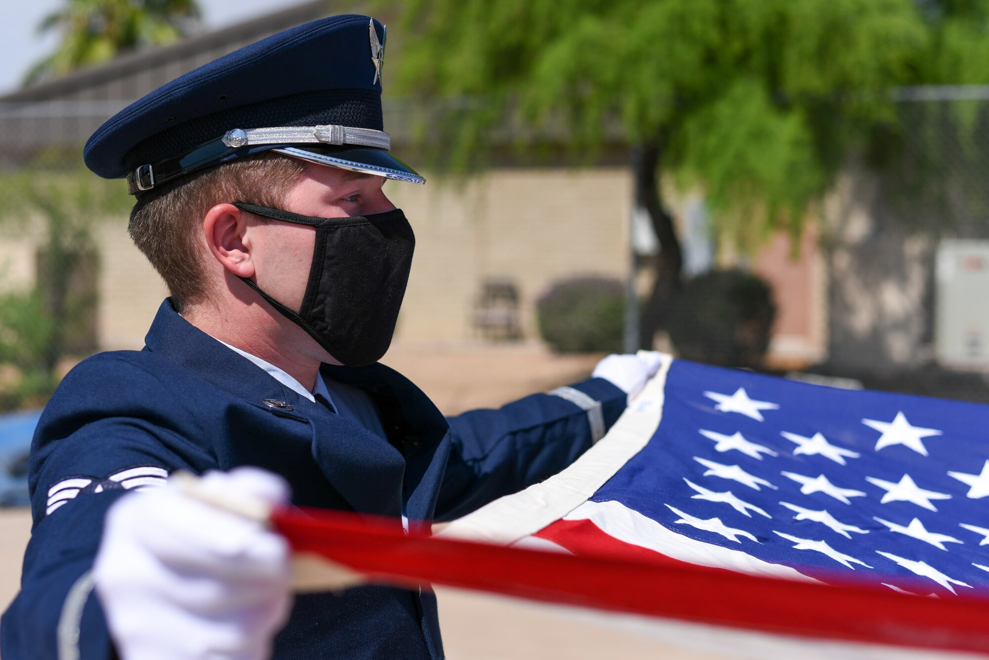 U.S. Air Force Senior Airman Blake Davidson, 56th Fighter Wing ceremonial guardsman, displays the American flag during a flag folding ceremony July 28, 2021, at Luke Air Force Base, Arizona. The Luke AFB Honor Guard is responsible for a large amount of Arizona’s ceremonies, providing coverage to six different counties. The base honor guard’s primary mission is to provide military funeral honors for active-duty members as well as retirees and veterans who served honorably in the U.S. Air Force and Army Air Corps. (U.S. Air Force photo by Senior Airman Caleb F. Butler)