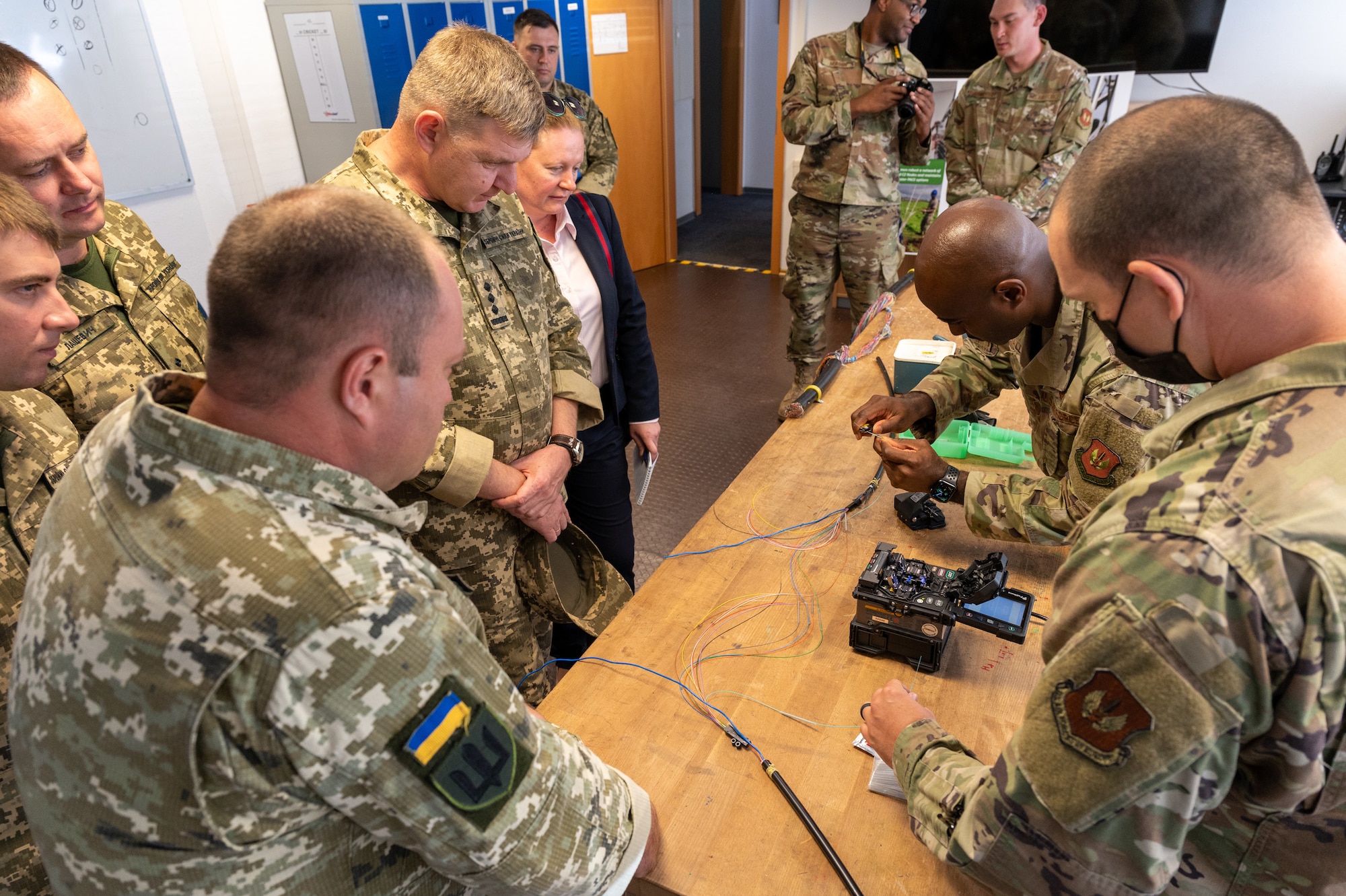 Service members standing around a table with fiber cables.