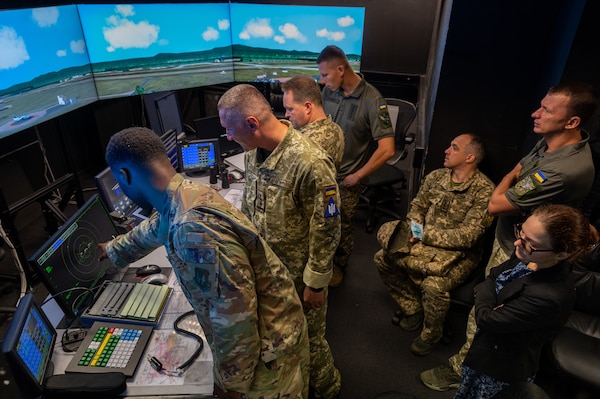 Air Force Staff Sergeant Jalah Patten, 86th Operations Support Squadron air traffic control tower watch supervisor, left, shows members of Ukrainian armed forces tower simulator system during their visit to Ramstein Air Base, Germany, August 5, 2021 (U.S. Air Force/John R. Wright)