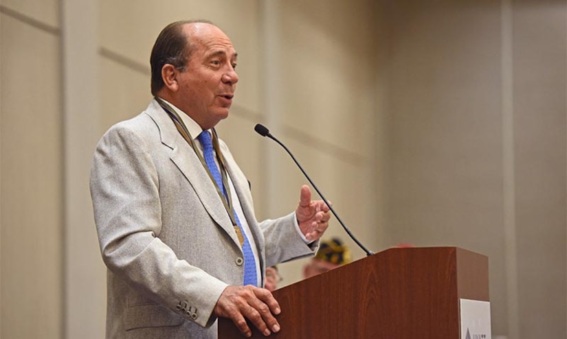 A man speaks into a microphone that's mounted on a lectern.