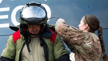 Col. Mark Dmytryszyn, 2nd Bomb Wing commander, puts on a bomb suit with the help of Senior Airman Janie Roberts, 2nd Civil Engineer Squadron explosive ordnance disposal technician, at Barksdale Air Force Base, Louisiana, Aug. 9, 2021. Dmytryszyn visited the EOD unit to further familiarize himself with the unit's mission and to understand the needs of the Airmen. (U.S. Air Force photo by Senior Airman Jacob B. Wrightsman)