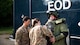 Col. Mark Dmytryszyn, 2nd Bomb Wing commander, puts on a bomb suit with the help of Airman 1st Class Paris Permenter, left, and Senior Airman Janie Roberts, middle, 2nd Civil Engineer Squadron explosive ordnance disposal technicians, at Barksdale Air Force Base, Louisiana, Aug. 9, 2021. During his visit, Dmytryszyn conducted a simulated operation involving a training improvised explosive device. (U.S. Air Force photo by Senior Airman Jacob B. Wrightsman)