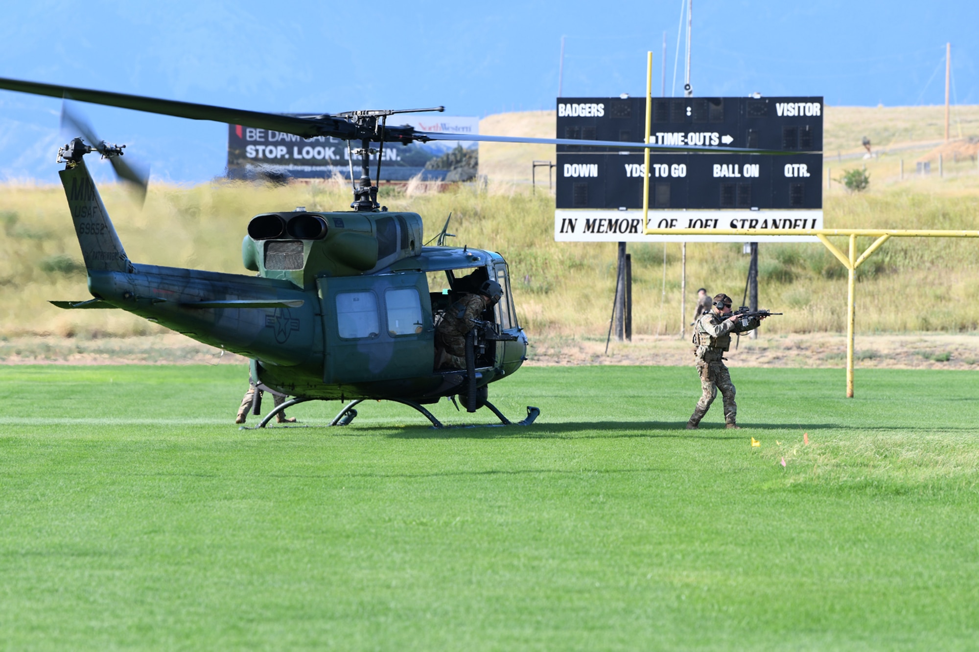 Personnel from the 341st Missile Security Operations Squadron exit a UH-1N Huey helicopter upon landing on the football field at Cascade School Aug 9, 2021, in Cascade, Mont. The 341st MSOS convoy response force and the 40th Helicopter Squadron assisted TRF in the participation of the LIRP training exercise, designed to prepare defenders and Malmstrom leadership for real-world emergency situations. (U.S. Air Force photo by Airman Elijah Van Zandt)