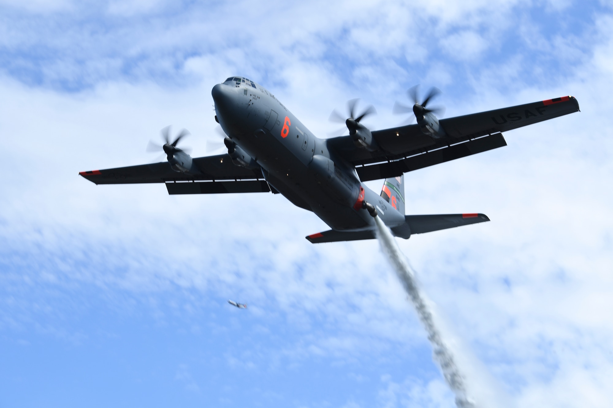 A MAFFS C-130 aircraft drops a water load in the Tahoe National Forest for a training exercise.