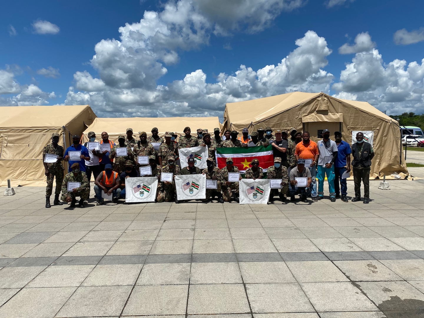 Members of the Surinamese Army, the Ministry of Health and National Coordination Center for Disaster Relief trainees pose in front of an assembled Mobile Hospital Package in Suriname during a ceremony July 23. The hospital, procured by DLA Troop Support's Construction and Equipment supply chain, was donated to the country through U.S. Southern Command's Humanitarian Assistance Program to assist with the pandemic.
