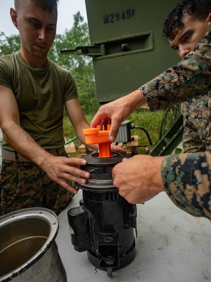 Marines with Combat Logistics Battalion 451, 4th Marine Logistics Group, replace a component of a water pump with a part 3D-printed in the field during Northern Strike 21-2 at Camp Grayling, Michigan on Aug. 7, 2021. Northern Strike is an annual exercise hosted by the National Guard aboard the National All-Domain Warfighting Center at Camp Grayling, MI. Reserve Marines with Combat Logistics Battalion 451 are providing direct and general support to Joint Task Force 85, increasing interoperability with sister services and integrating with the Active Component. (U.S. Marine Corps photo by Lance Cpl. Colby Bundy)