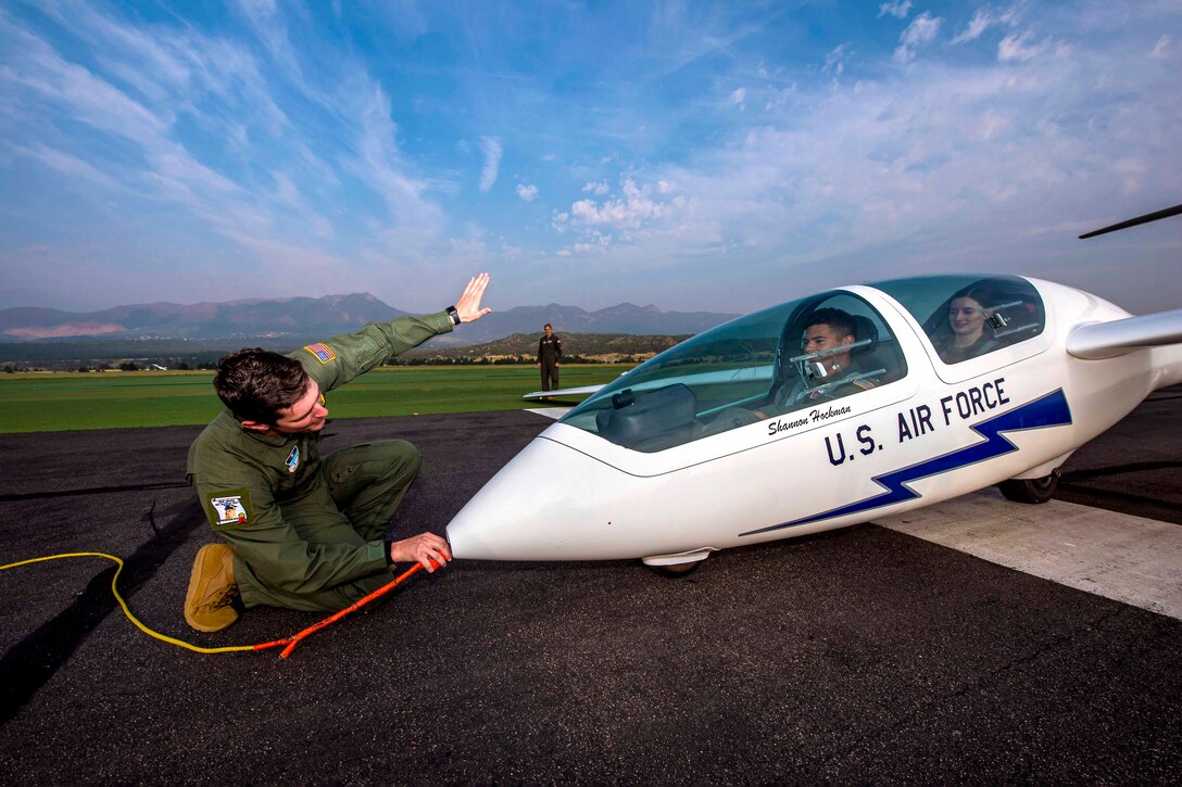 An Air Force cadet connects a tow rope to a glider.