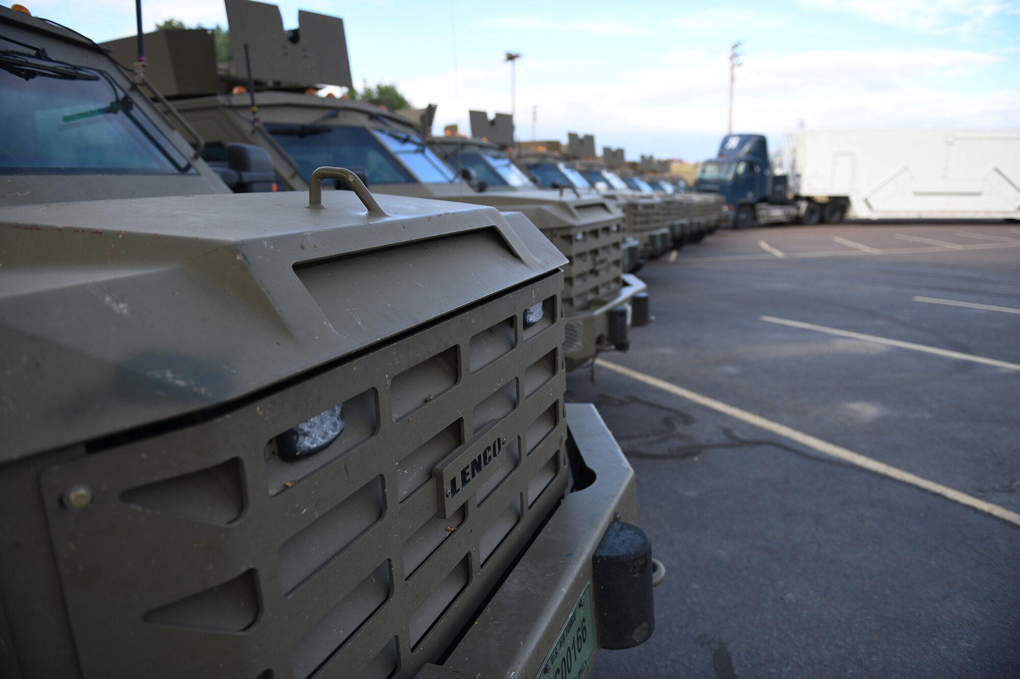 A row of Bearcat vehicles and a payload transporter are displayed during a Local Integrated Response Plan at Cascade School Aug. 9, 2021, in Cascade, Mont. The real-world training exercise included Bearcat vehicles escorting a payload transporter from Malmstrom to the school and wrapped up with two UH-1N Huey helicopters landing on the football field. (U.S. Air Force photo by Airman Elijah Van Zandt)