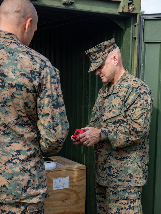Lt. Gen. David G. Bellon, Commander, Marine Forces Reserve and Marine Forces South, and Chief Warrant Officer Anthony Brown, a motor transport maintenance officer with Combat Logistics Battalion 451, 4th Marine Logistics Group, discuss a makeshift phone 3D-printed in the field during Northern Strike 21-2 at Camp Grayling, Michigan on Aug. 9, 2021. Reserve Marines with Combat Logistics Battalion 451 are providing direct and general support to Joint Task Force 85 as a part of Northern Strike 21-2. (U.S. Marine Corps photo by Lance Cpl. Colby Bundy)
