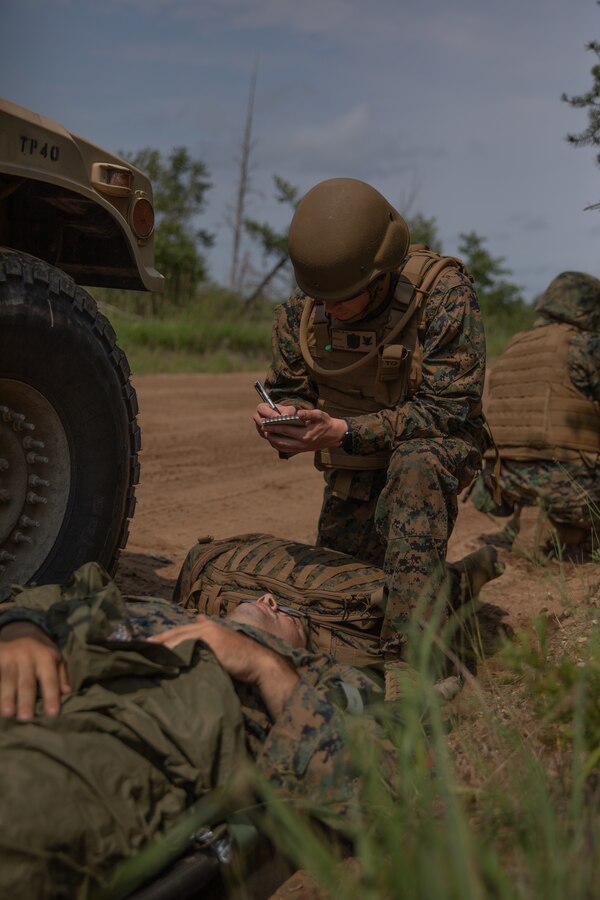 A U.S. Navy Corpsman with Combat Logistics Battalion 451, 4th Marine Logistics Group, assesses a simulated casualty during Northern Strike 21-2 at Camp Grayling, Michigan on Aug. 8, 2021. Northern Strike is an annual exercise hosted by the National Guard aboard the National All-Domain Warfighting Center at Camp Grayling, MI. Reserve Marines with Combat Logistics Battalion 451 are providing direct and general support to Joint Task Force 85, increasing interoperability with sister services and integrating with the Active Component. (U.S. Marine Corps photo by Cpl. James Stanfield)