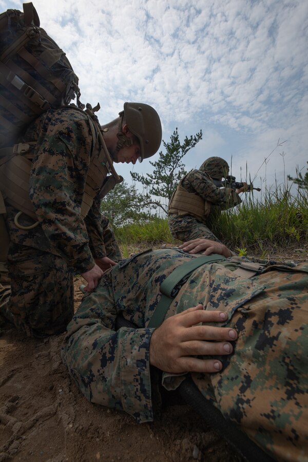 A U.S. Navy Corpsman with Combat Logistics Battalion 451, 4th Marine Logistics Group, assesses a simulated casualty during Northern Strike 21-2 at Camp Grayling, Michigan on Aug. 8, 2021. Northern Strike is an annual exercise hosted by the National Guard aboard the National All-Domain Warfighting Center at Camp Grayling, MI. Reserve Marines with Combat Logistics Battalion 451 are providing direct and general support to Joint Task Force 85, increasing interoperability with sister services and integrating with the Active Component. (U.S. Marine Corps photo by Cpl. James Stanfield)