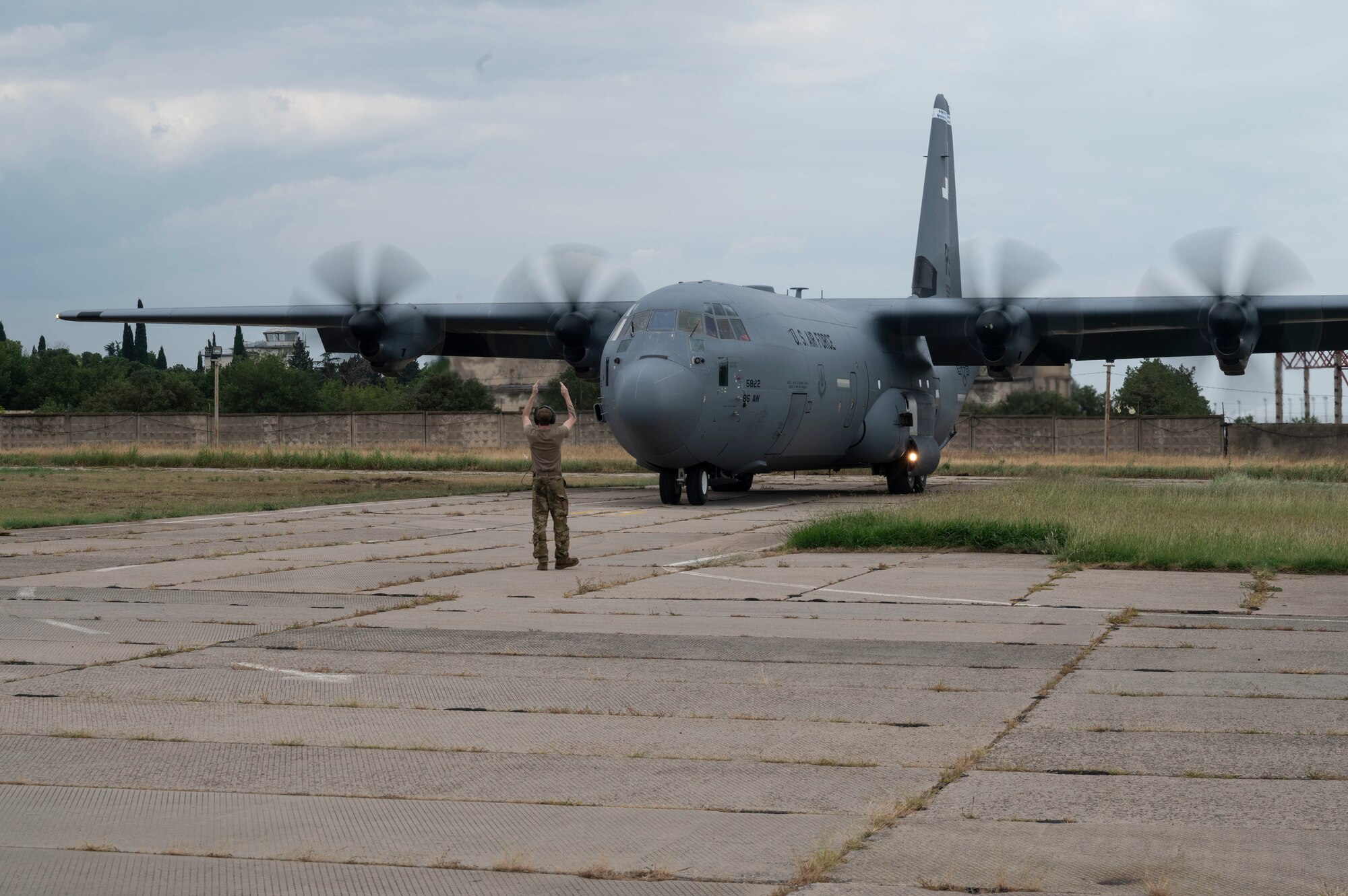 U.S. Air Force Staff Sgt. Alex Smelcer, 86th Aircraft Maintenance Squadron flight crew chief, marshals a C-130J Super Hercules aircraft onto the flightline during exercise Agile Spirit 21