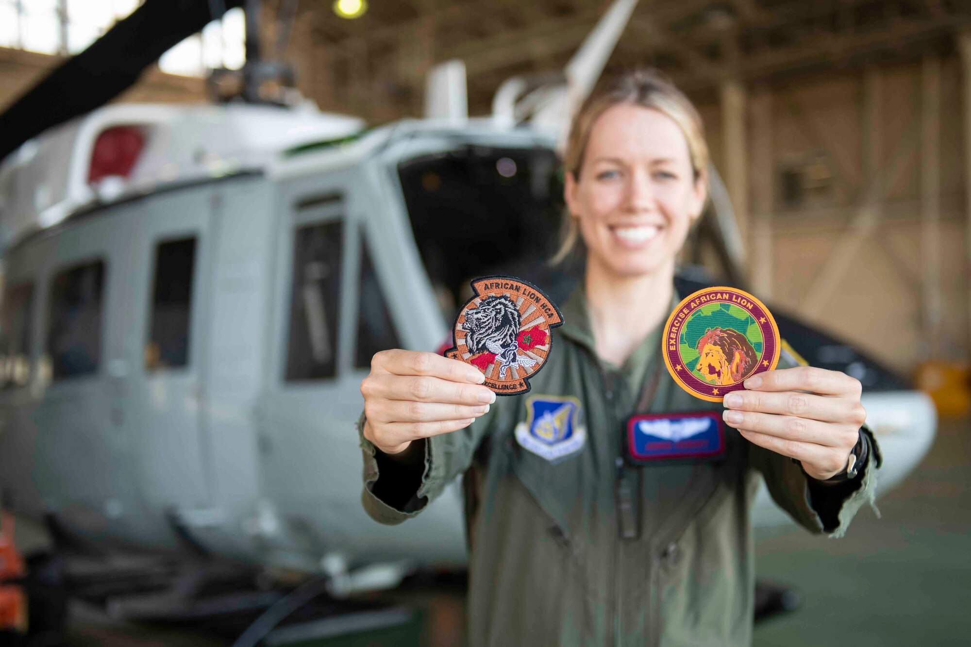 Capt. Jennie Seibert, 459th Airlift Squadron UH-1N Huey pilot and chief of training, shows off her patches from Exercise African Lion 2021 at Yokota Air Base, Japan, Aug. 4, 2021.