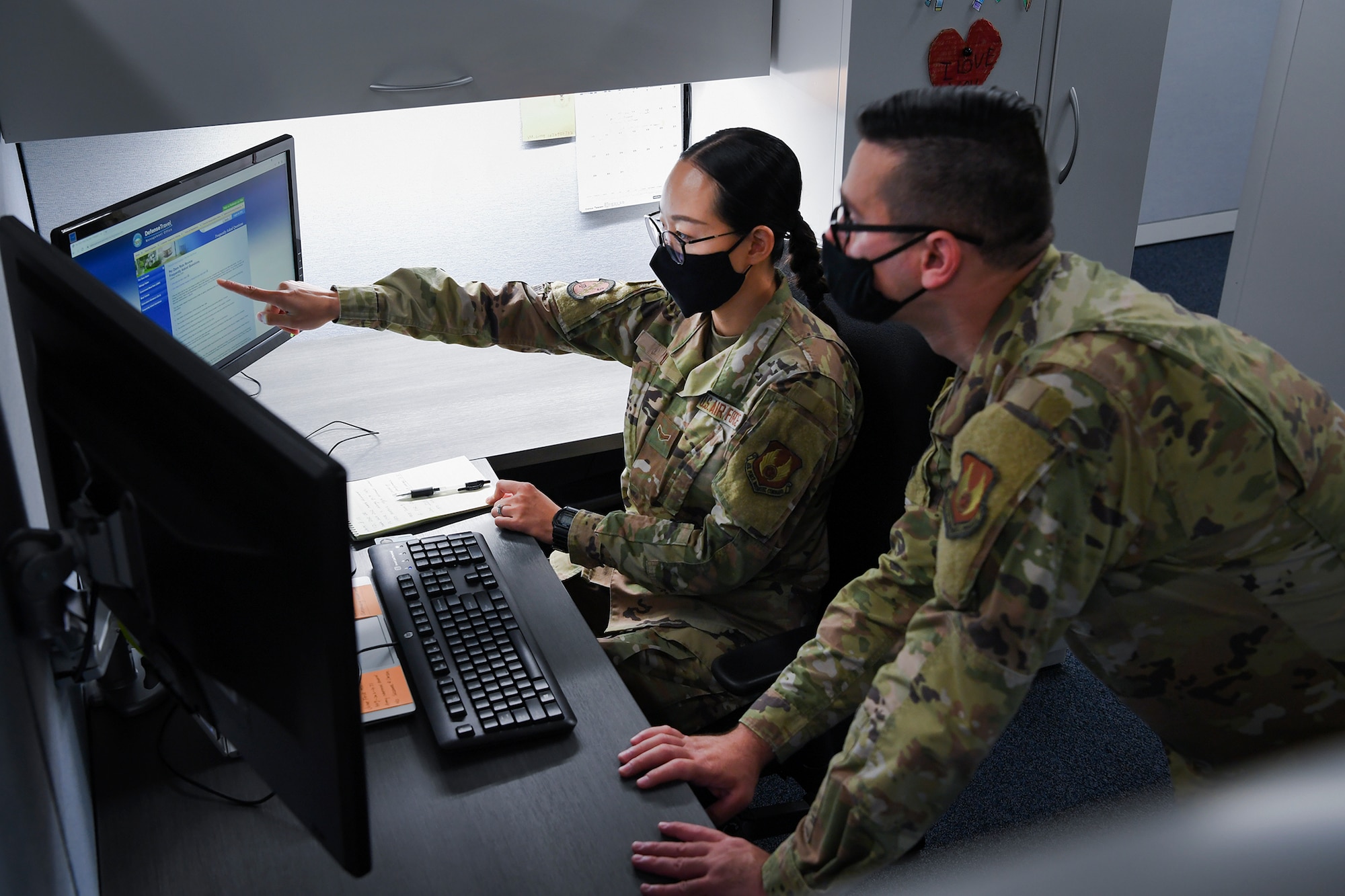 Two Airmen looking at computer screens