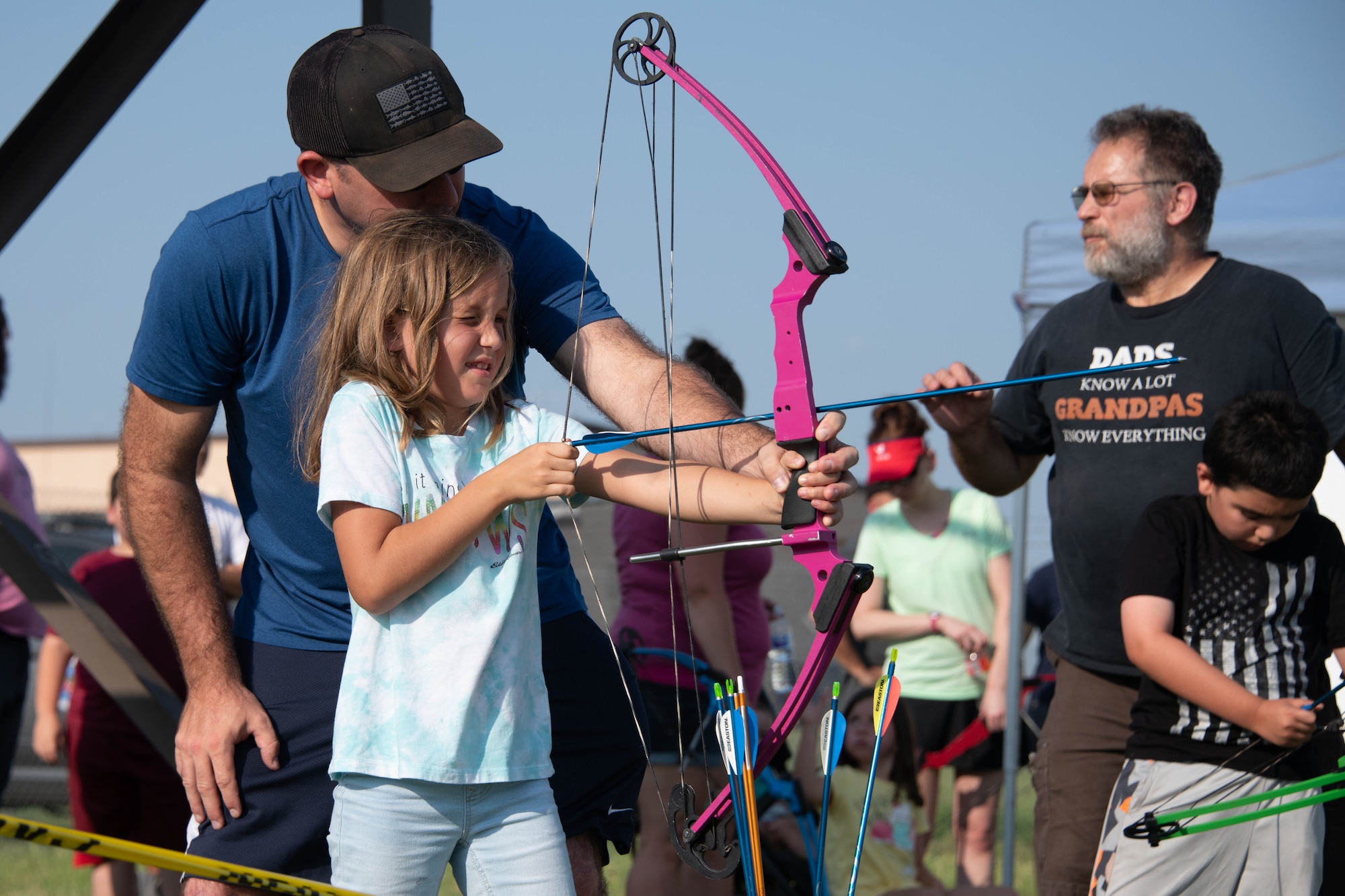 U.S. Air Force Master Sgt. Nathan Allen, 97th Air Mobility Wing Public Affairs superintendent, helps his daughter, Genevieve, shoot a bow at targets on Altus Air Force Base, Oklahoma, July 30th, 2021. Allen and other airmen, along with their families, were able to learn about the variety of activities and excursions that the 97th Force Support Squadron outdoor recreation office has to offer. (U.S. Air Force Photo by Airman 1st Class Trenton Jancze)