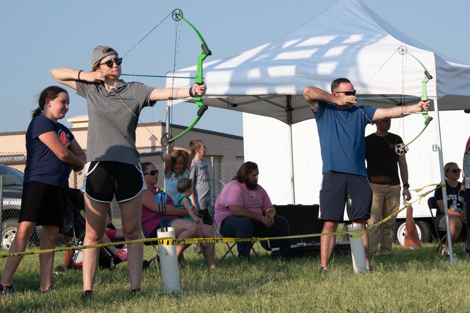 U.S. Air Force Airman 1st Class Kayla Christenson, 97th Air Mobility Wing (AMW) public affairs apprentice, and Master Sgt. Nathan Allen, 97th AMW public affairs superintendent, shoot arrows at targets on Altus Air Force Base, Oklahoma, July 30th, 2021. The 97th Force Support Squadron outdoor recreation office offers outdoor-centric equipment to airmen and their families to enjoy during the week and over weekends. (U.S. Air Force Photo by Airman 1st Class Trenton Jancze)