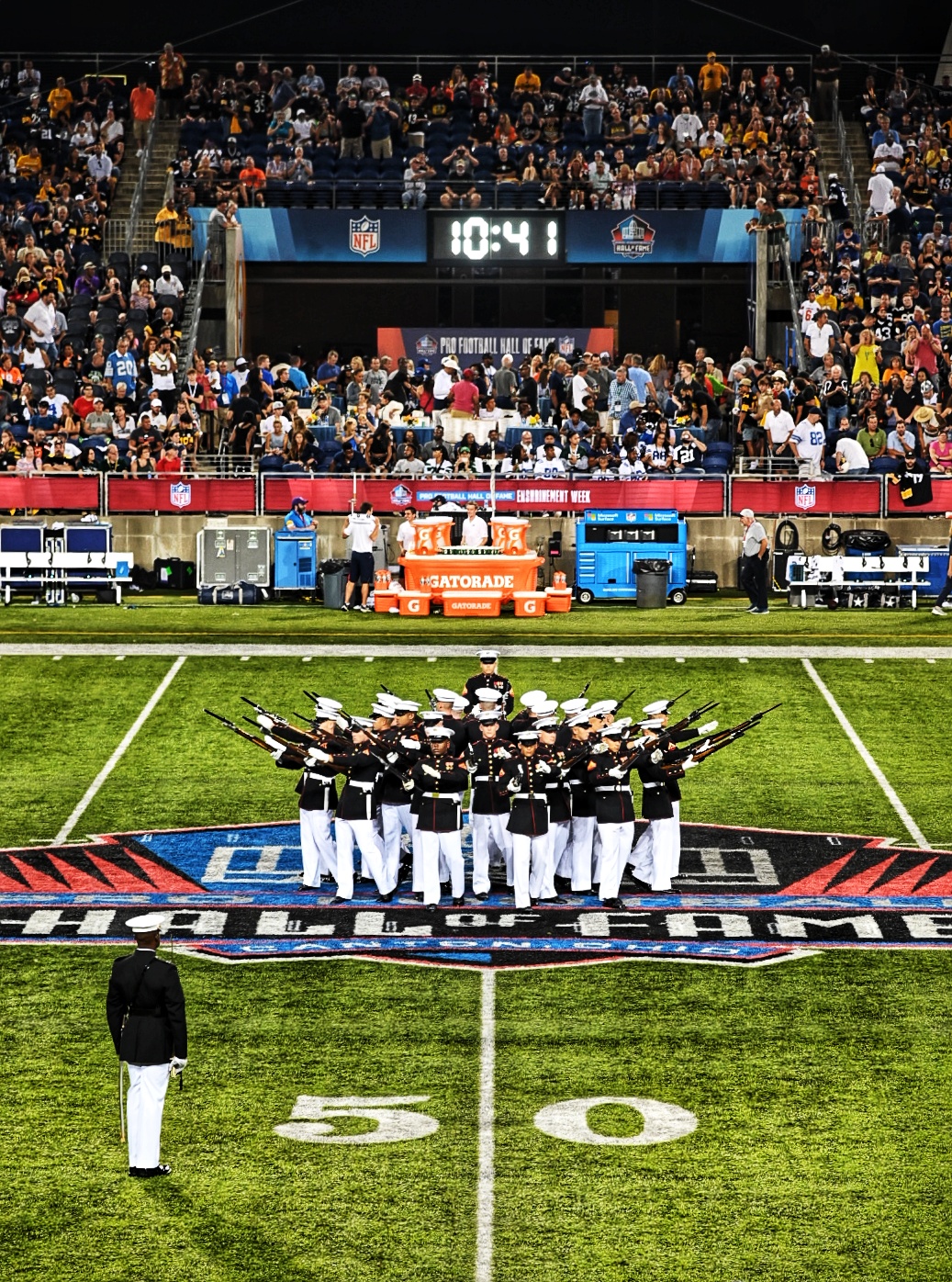 A Marine Corps Silent Drill Platoon, from Marine Barracks Washington, D.C., also known as "8th & I," performed during the Pro Football Hall of Fame Game in Canton, Ohio on August 5. The performance supported the dual-district partnership between the 1st and 4th Marine Corps Recruiting Districts in order to increase awareness in support of recruiting operations.  Other events during the engagement included a Marine on field to conduct the Hall of Fame Game Coin Toss, recruiters manned a promotional booth during the 3-day FunFest, and a Marine Corps Junior Reserve Officer Training Corps Color Guard presented the colors during the National Anthem.