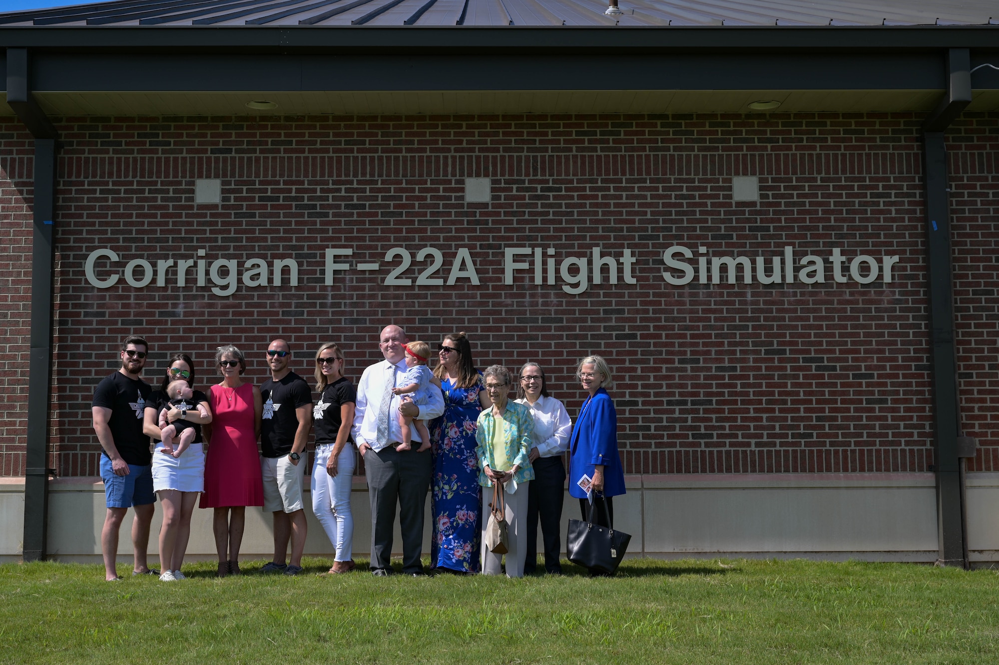 Family members pose in front of a flight simulator.
