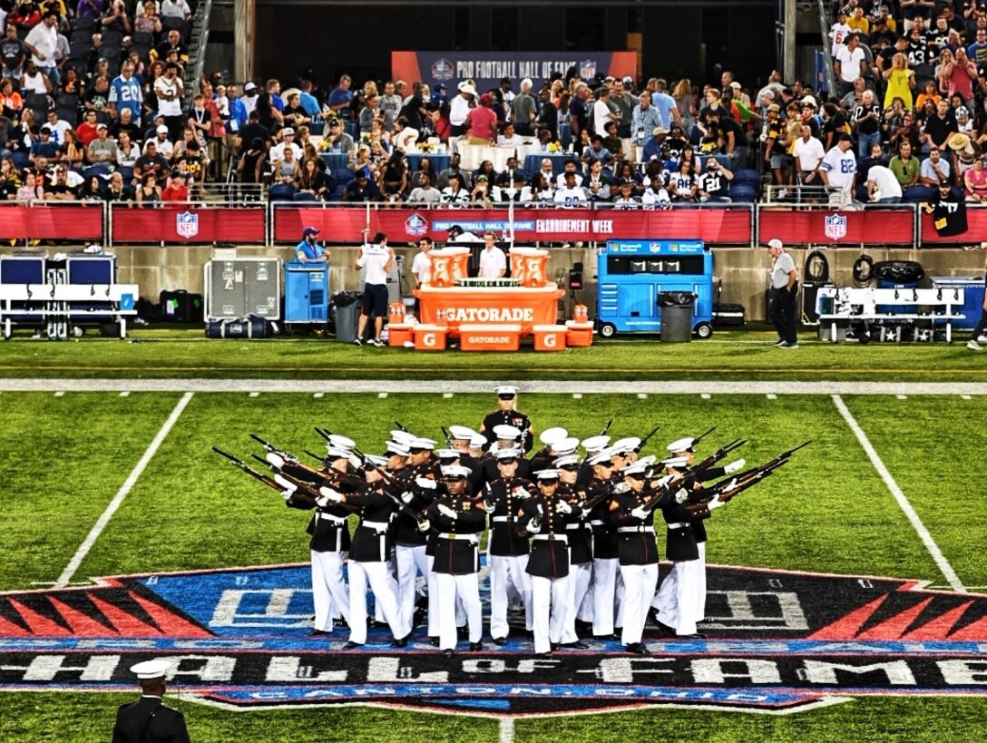 A Marine Corps Silent Drill Platoon, from Marine Barracks Washington, D.C., also known as "8th & I," performed during the Pro Football Hall of Fame Game in Canton, Ohio on August 5. The performance supported the dual-district partnership between the 1st and 4th Marine Corps Recruiting Districts in order to increase awareness in support of recruiting operations.  Other events during the engagement included a Marine on field to conduct the Hall of Fame Game Coin Toss, recruiters manned a promotional booth during the 3-day FunFest, and a Marine Corps Junior Reserve Officer Training Corps Color Guard presented the colors during the National Anthem.