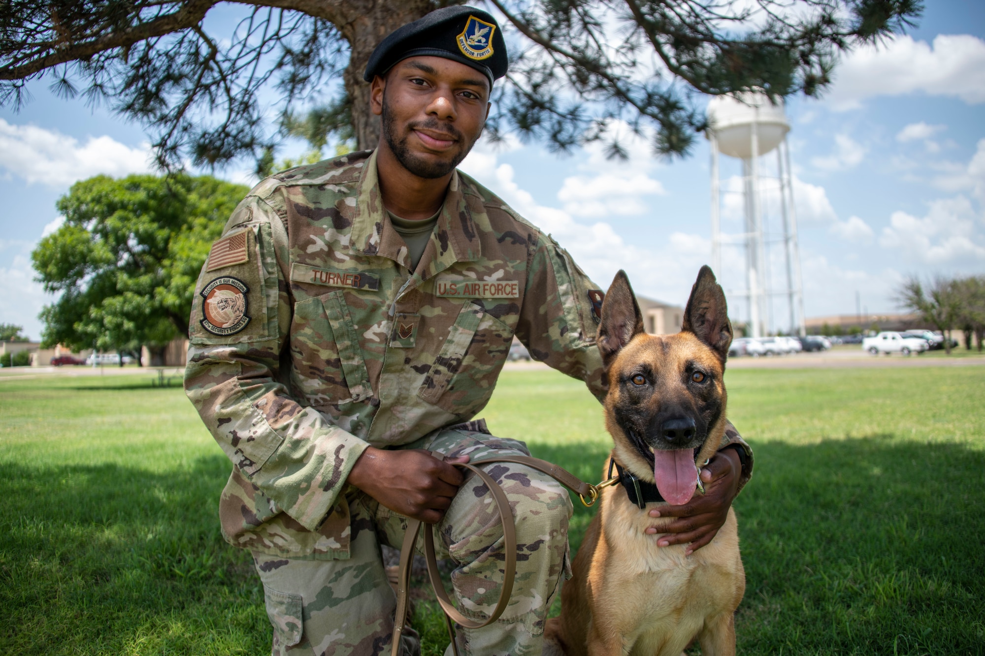 U.S. Air Force Staff Sgt. DeAndre Turner, 97th Security Forces Squadron Military Working Dog (MWD) handler, kneels next to his MWD, “Bess,” at Altus Air Force Base, Oklahoma, July 28, 2021. MWD teams will switch handlers and dogs to build their individual competencies. (U.S. Air Force photo by Staff Sgt. Cody Dowell)